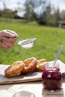 a person is grilling donuts on a table at Obermoserhof in Feldthurns