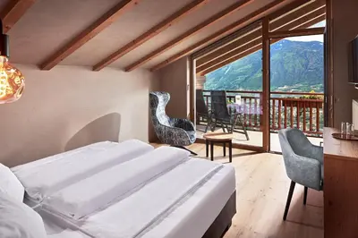 a bedroom with a bed and a balcony at Hotel-Garni Ehrenfels in Schenna