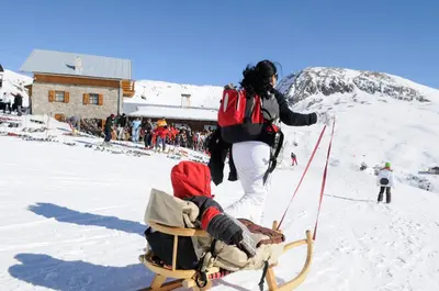 a woman pulling a child on a sled in the snow at Hotel-Garni Ehrenfels in Schenna
