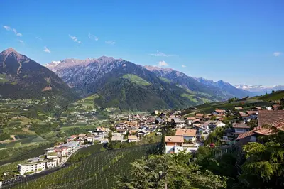 a village in a valley with mountains in the background at Hotel-Garni Ehrenfels in Schenna