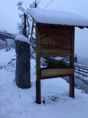a sign in the snow next to a fence at BUEHLERHOF Urlaub mit Kind & Hund, Obst-& Weingut, Brixen in Rosa