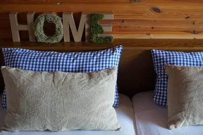 a couch with pillows and a sign that says home at BUEHLERHOF Urlaub mit Kind & Hund, Obst-& Weingut, Brixen in Rosa