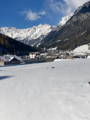 a snow covered field with a town and mountains at Villa Alessandra in Colle Isarco