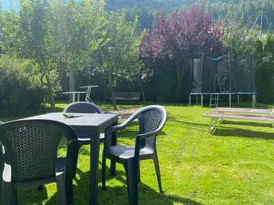 two chairs and a table in a yard with a picnic table at Villa Alessandra in Colle Isarco