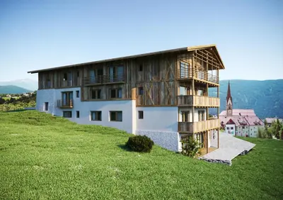 a house on top of a hill with a green field at Chalet Schmied in Terento