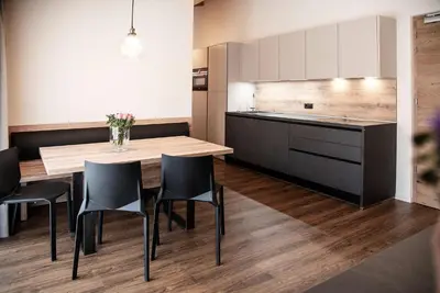 a kitchen and dining room with a wooden table and chairs at Chalet Schmied in Terento
