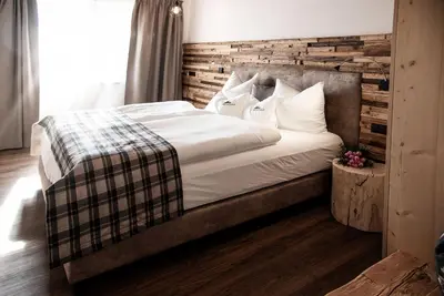 a bedroom with a large bed with a wooden headboard at Chalet Schmied in Terento