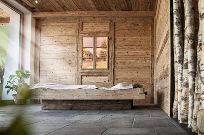 a wooden room with a bed and a window at Chalet Schmied in Terento