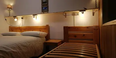 a bedroom with two beds and lights on the wall at CasaMau Trilo in Campitello di Fassa
