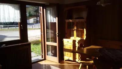a room with an open door with a dresser and a window at CasaMau Trilo in Campitello di Fassa