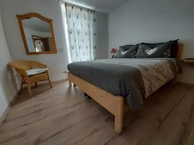 a bedroom with a bed and a mirror and a chair at Casa Rita in Tesero