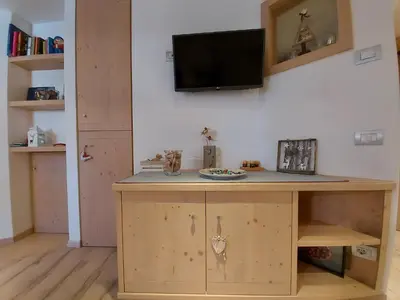 a room with a desk with a tv on the wall at Casa Rita in Tesero