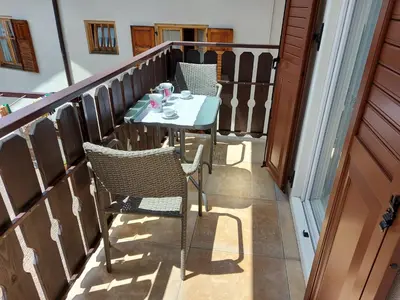 a small table and chairs on a balcony at Casa Rita in Tesero