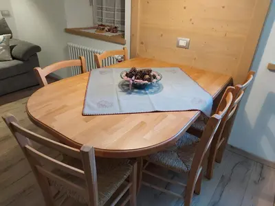 a wooden table with chairs and a bowl of fruit on it at Casa Rita in Tesero