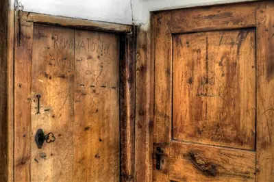 an old wooden door with graffiti on it at Ciasa Medalghes in San Martino in Badia