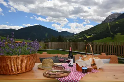 a picnic table with a basket of food and wine at Agriturismo Anví in Badia