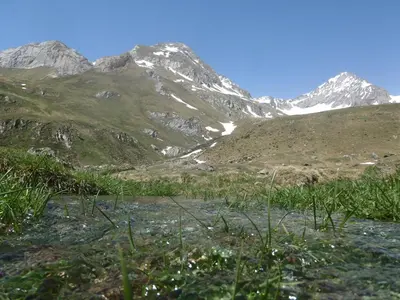 a mountain range with a river in the foreground at Plattnerhof in Fundres
