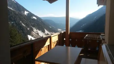 a table on a balcony with a view of mountains at Plattnerhof in Fundres