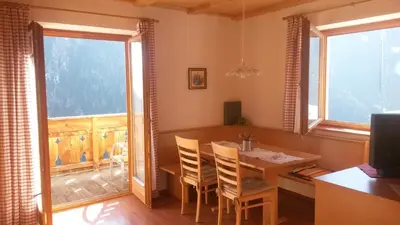 a dining room with a table and chairs and a window at Plattnerhof in Fundres