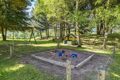 a play area with a playground with a play house at Residence Des Alpes in Cavalese