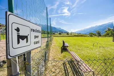 a sign on a fence next to a field at Residence Des Alpes in Cavalese