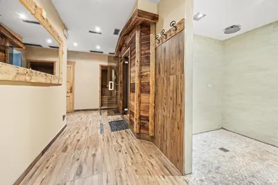 a hallway with wooden floors and a large wooden door at Residence Des Alpes in Cavalese