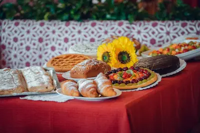 a table topped with different types of bread and pastries at Residence Des Alpes in Cavalese