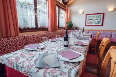 a table in a restaurant with a bottle of wine at Residence Des Alpes in Cavalese