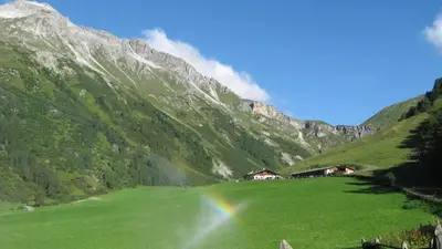a rainbow in a green field with a mountain at Casa da Aldo in Castelfondo