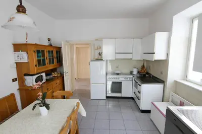 a kitchen with white appliances and a table in it at Casa da Aldo in Castelfondo
