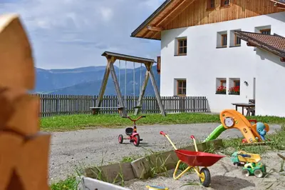 a playground with toys in front of a house at Obererhof in SantʼAndrea in Monte