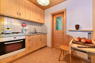 a kitchen with wooden cabinets and a table with apples on the counter at Obererhof in SantʼAndrea in Monte