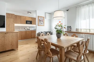 a kitchen and dining room with a wooden table and chairs at Chalet Falorie in Cortina dʼAmpezzo
