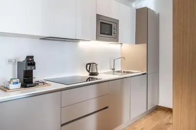 a kitchen with white cabinets and a sink at Chalet Falorie in Cortina dʼAmpezzo