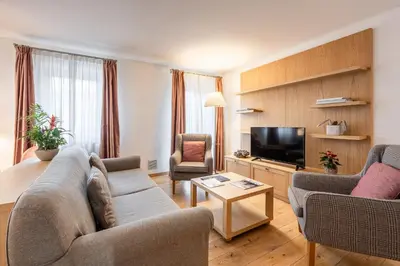 a living room with a couch and chairs and a tv at Chalet Falorie in Cortina dʼAmpezzo