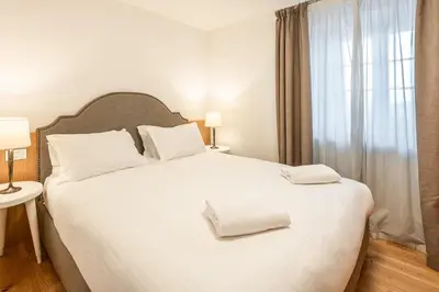 a bedroom with a large white bed with two towels on it at Chalet Falorie in Cortina dʼAmpezzo