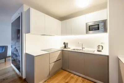 a kitchen with white cabinets and a sink at Chalet Falorie in Cortina dʼAmpezzo