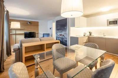 a living room with a glass table and chairs at Chalet Falorie in Cortina dʼAmpezzo