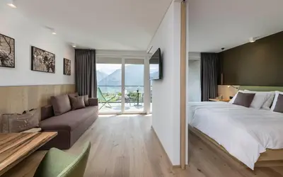 a bedroom with a large bed and a couch at Vinea - Apartments in Tirolo
