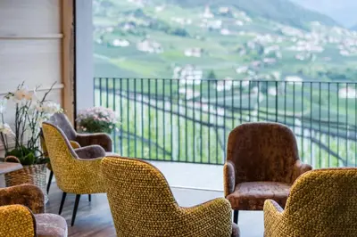 a group of chairs sitting on top of a balcony at Vinea - Apartments in Tirolo