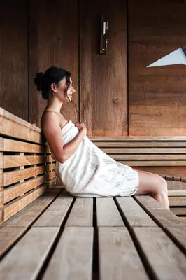 a woman in a white dress sitting on a bench at Hotel Panoramic Lotsch in Sarntal