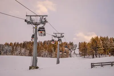 a ski lift with people on it in the snow at Hotel Panoramic Lotsch in Sarntal