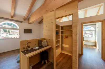 a tiny house with a desk and shelves at Le Suite della nonna Teresina in Moena