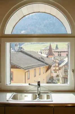 a window over a kitchen sink with a view at Le Suite della nonna Teresina in Moena