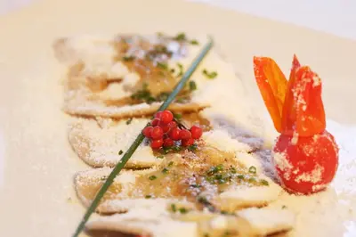 a plate of food on a white plate at Charme Hotel Uridl in Santa Cristina in Val Gardena