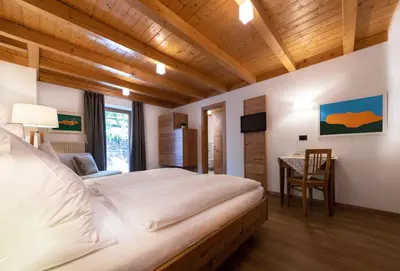 a bedroom with a large bed and a desk at Charme Hotel Uridl in Santa Cristina in Val Gardena