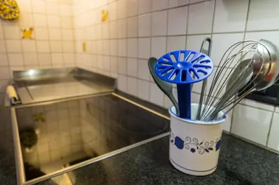 a cup filled with utensils sitting on a counter at Casa Trettel in Tesero