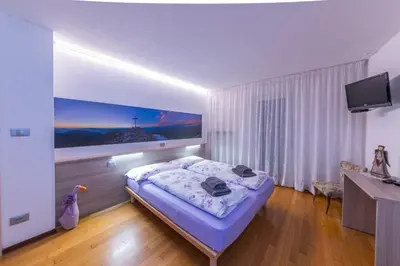 a bedroom with a bed and a tv on a wall at Casa Trettel in Tesero