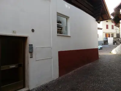 a white building with a door and a window at Casa Trettel in Tesero