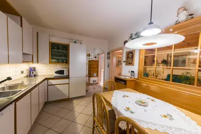 a kitchen and dining room with a table and a sink at Casa Trettel in Tesero